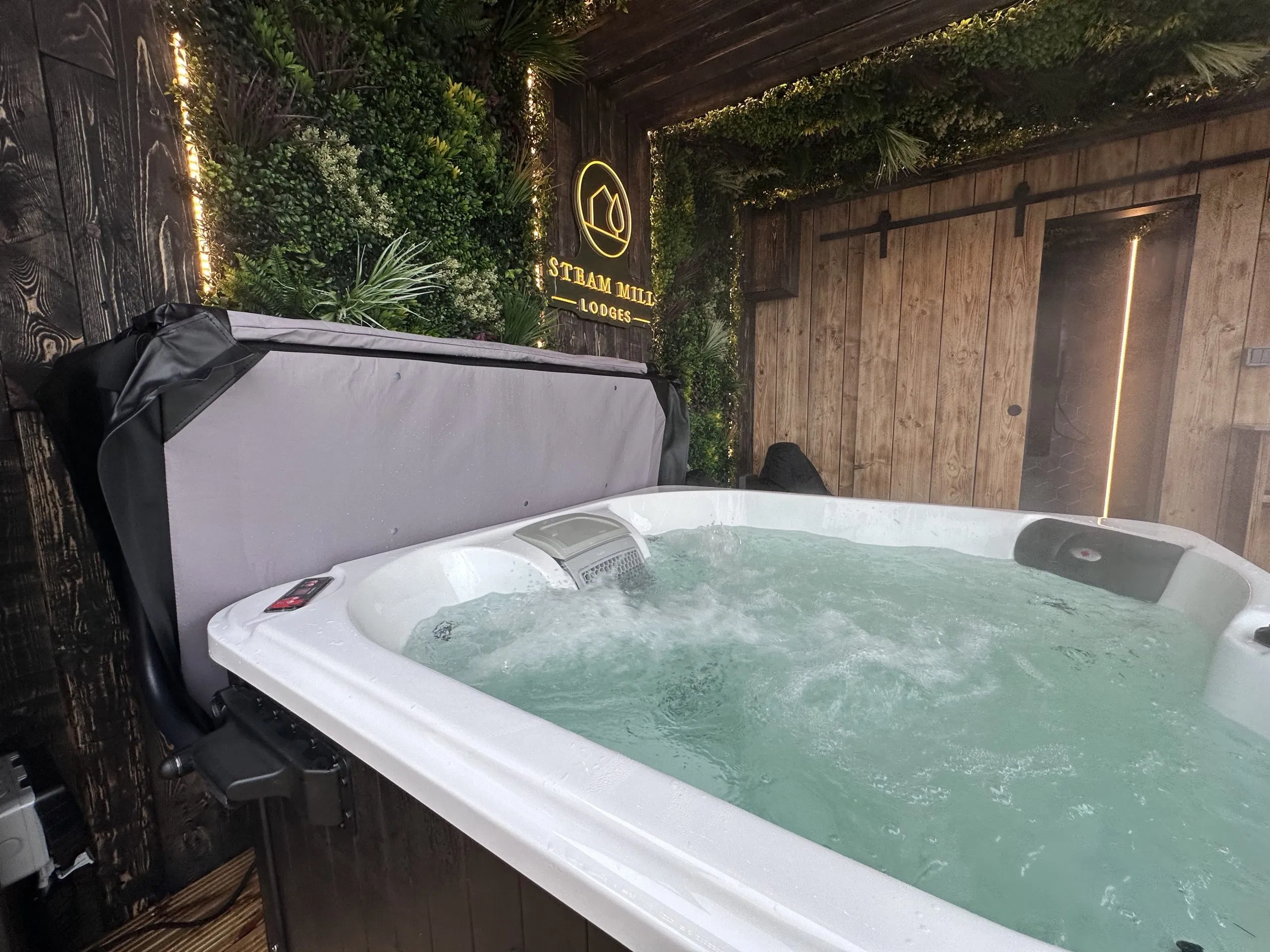 Undercover hot tub glowing after dark at Steam Mill Lodges