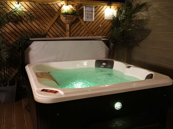 Undercover hot tub glowing after dark at Steam Mill Lodges
